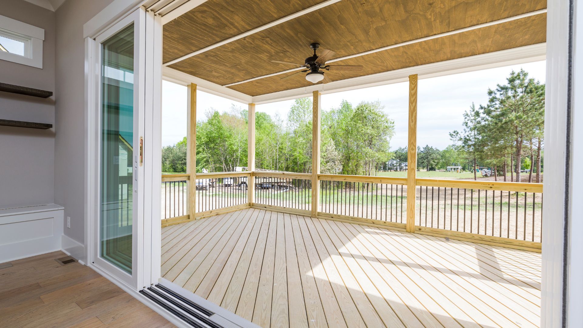 A porch with a ceiling fan and wooden floors